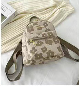 Floral-patterned backpack with a strap on a light background
