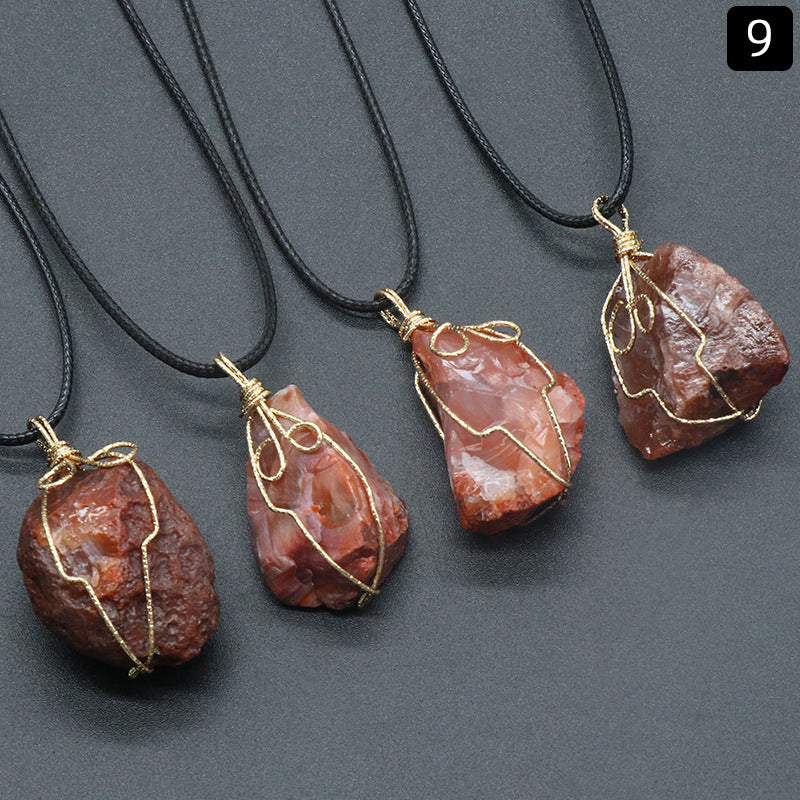 Three stone pendants on black cords against a gray background