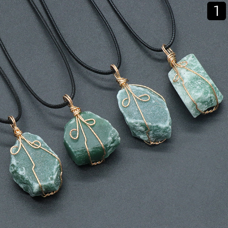 Green stone pendants with gold wire wrapping on black cords against a gray background