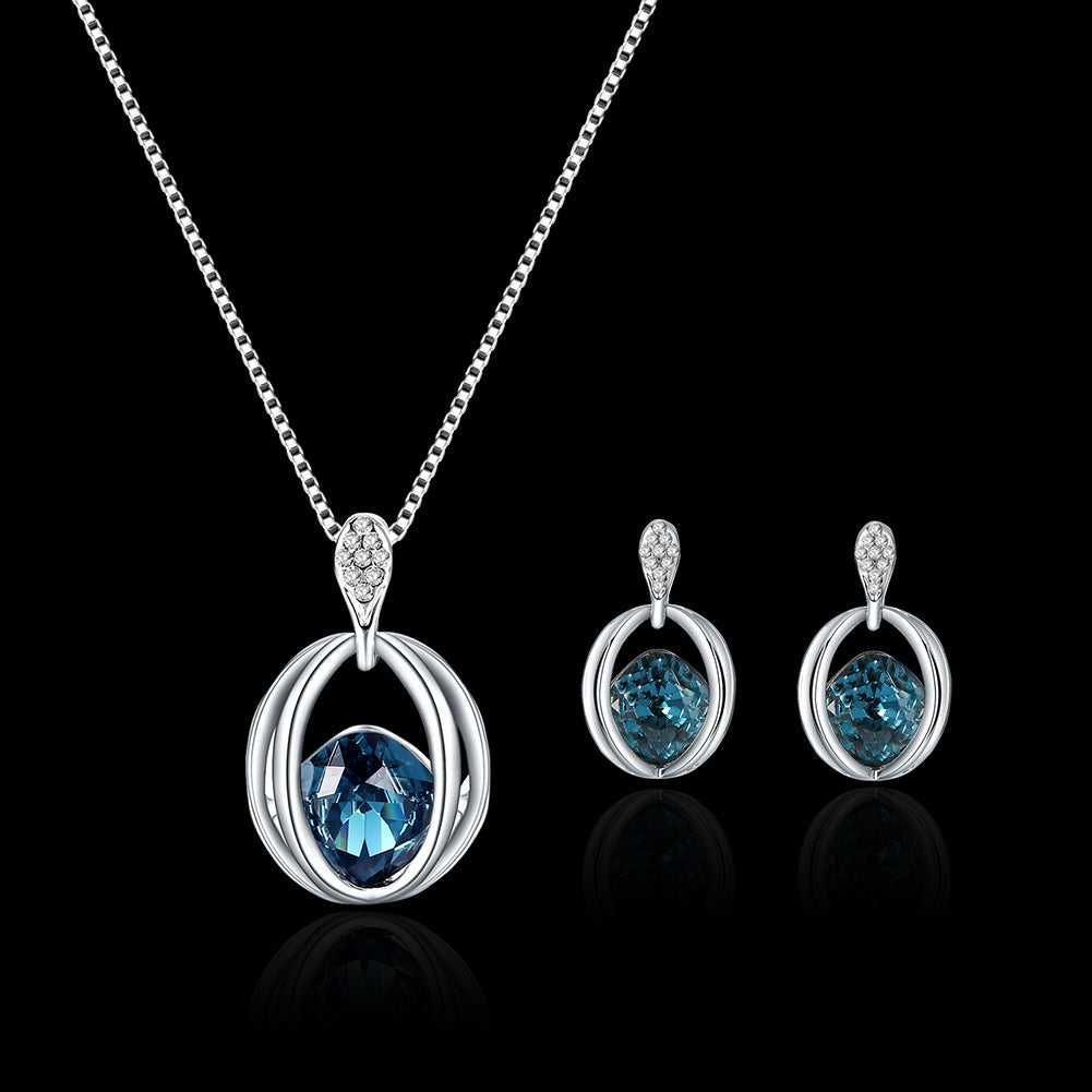 Silver jewelry set with blue gemstones on a black background