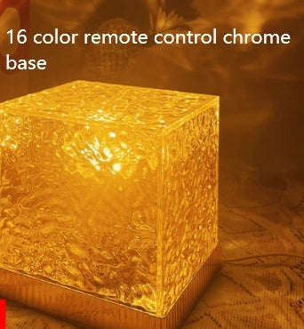 Gold cube-shaped light with '16 color remote control chrome base' text on a textured background