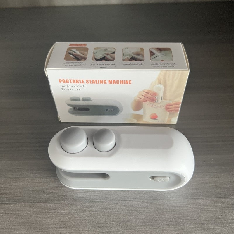 Portable sealing machine with packaging on a gray surface