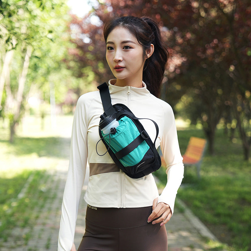 Woman wearing a green and black crossbody bag in a park setting