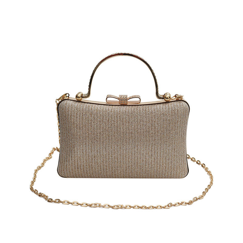Gold clutch bag with a chain strap on a white background
