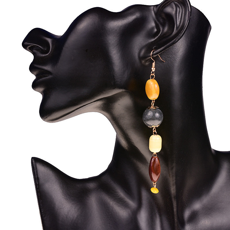 Earring with multicolored beads on a black mannequin ear