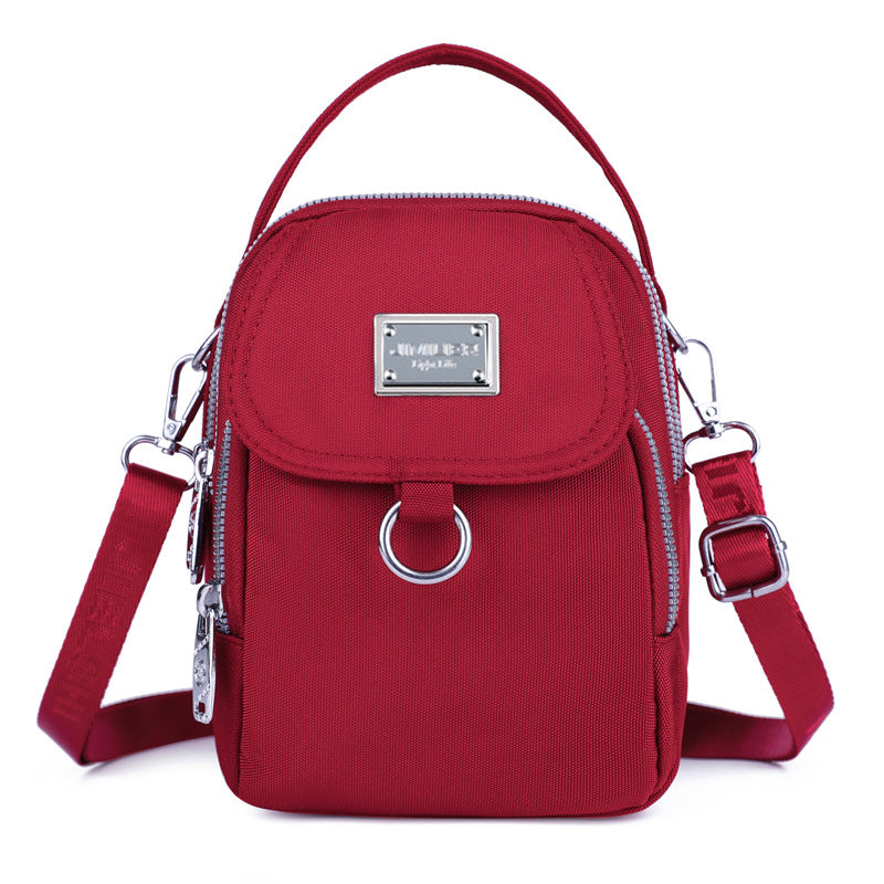 Red crossbody bag with silver accents on a white background