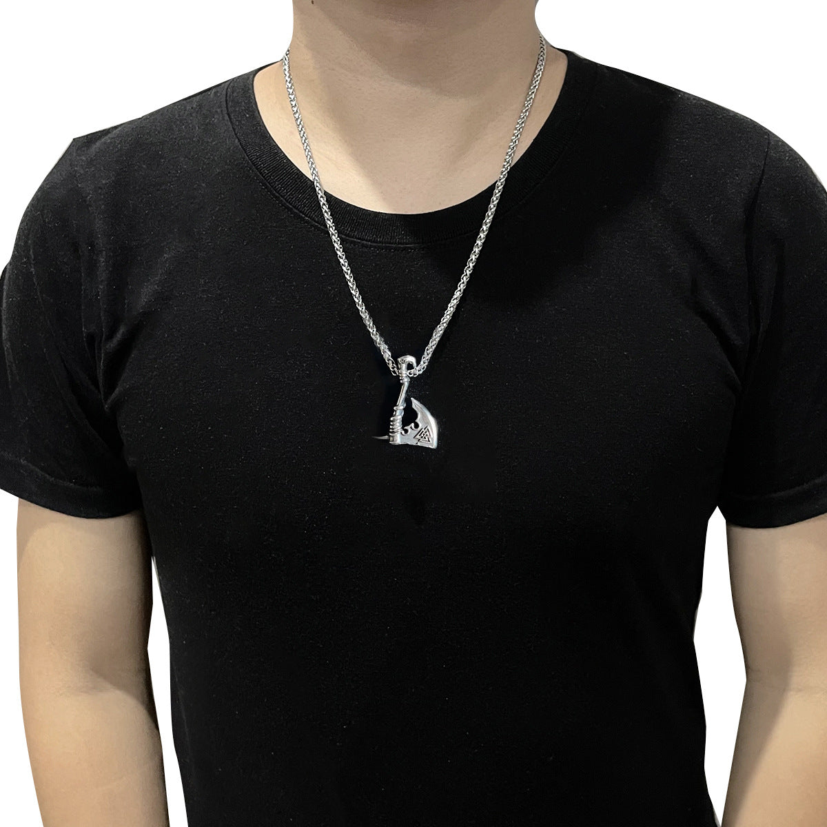 Person wearing a black t-shirt with a silver necklace featuring a pendant.