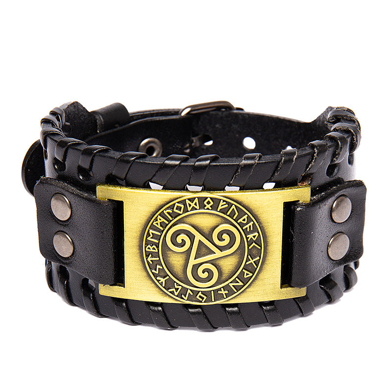 Black leather bracelet with a gold emblem featuring Celtic designs on a white background