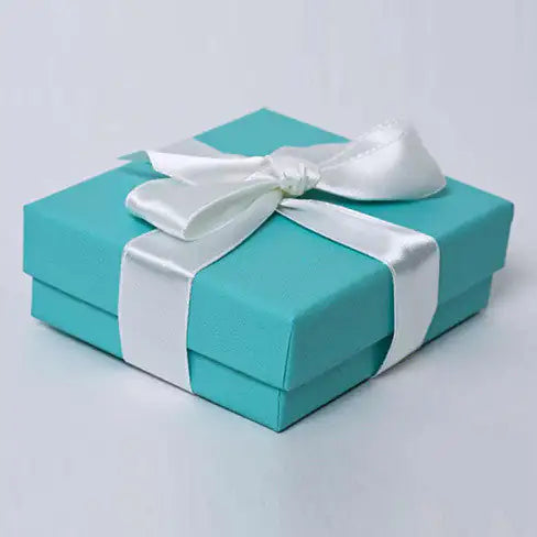 Turquoise gift box with a white ribbon on a light gray background