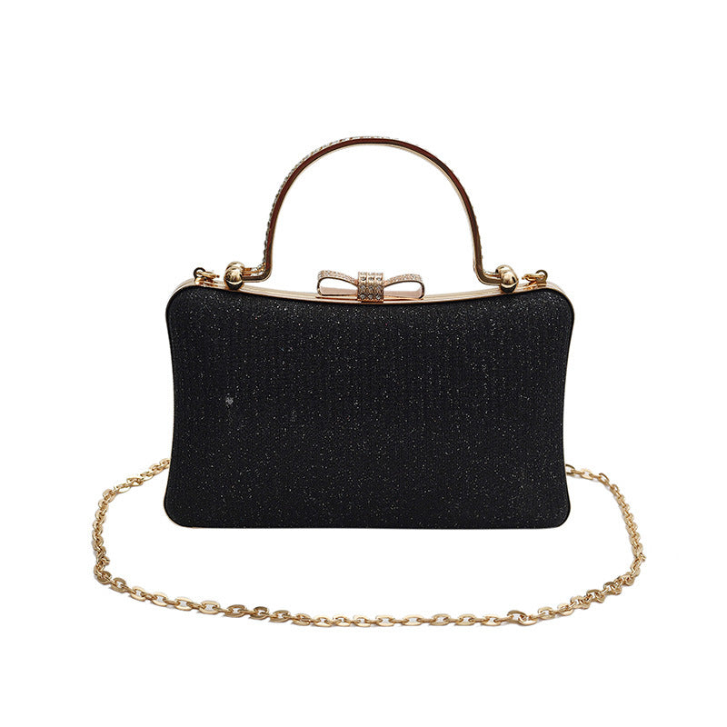 Black glittery handbag with a gold chain and handle on a white background