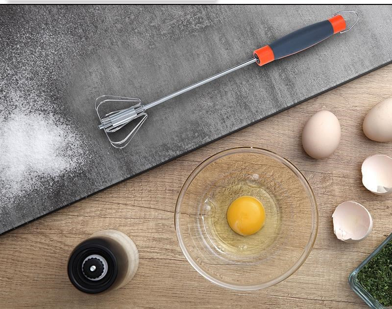 Glass bowl with an egg, whisk, and eggs on a wooden surface