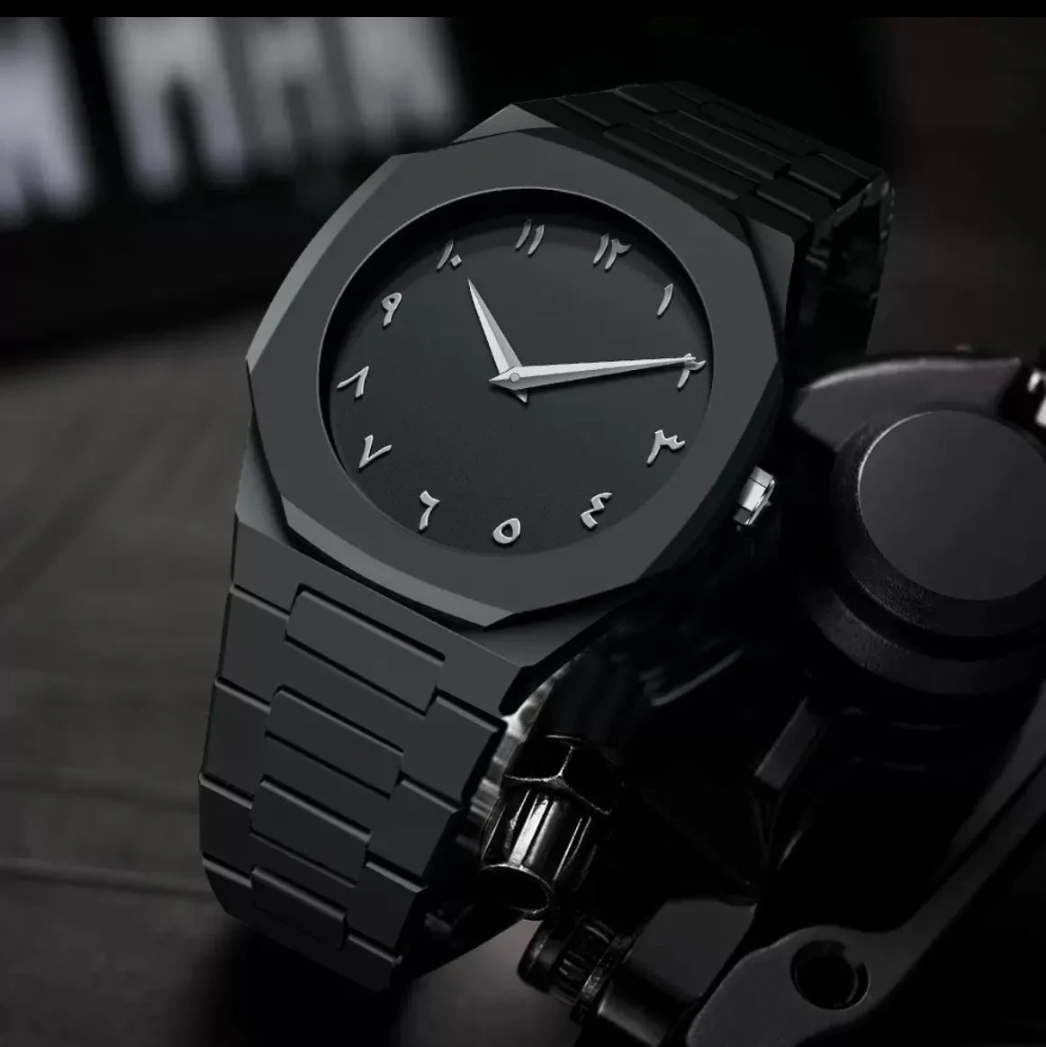 Black wristwatch with a metallic finish on a dark background