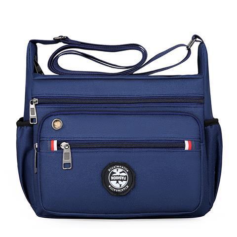 Blue crossbody bag with multiple zippers and a visible brand logo on a white background