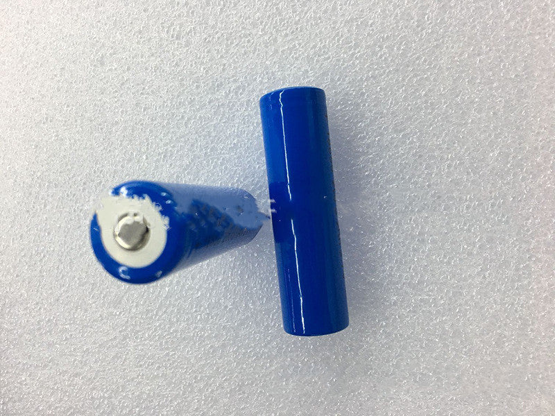 Two blue cylindrical batteries on a textured white surface