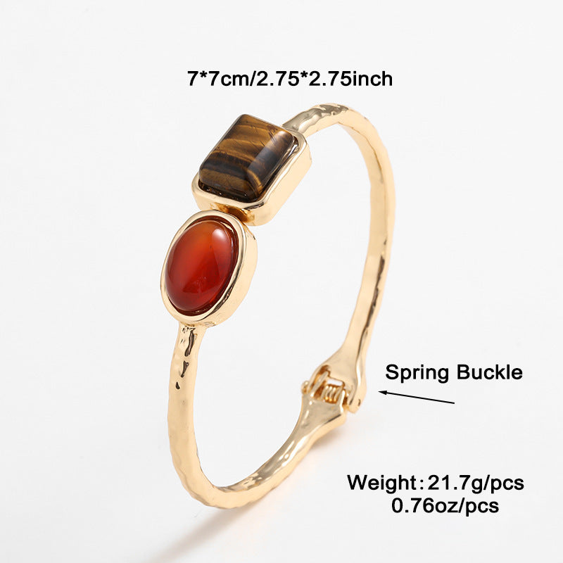 Gold ring with gemstones and measurements on a white background