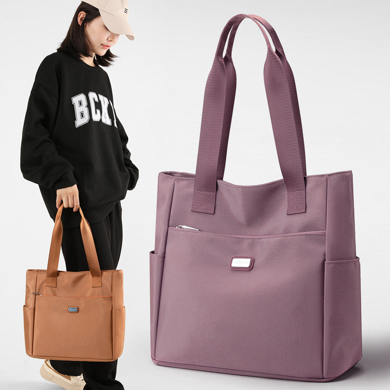 Woman holding a brown tote bag with a purple tote bag displayed prominently on a white background