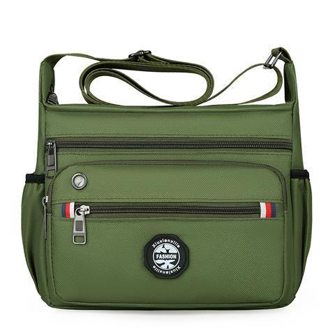 Green shoulder bag with multiple zippers and a visible brand logo on a white background