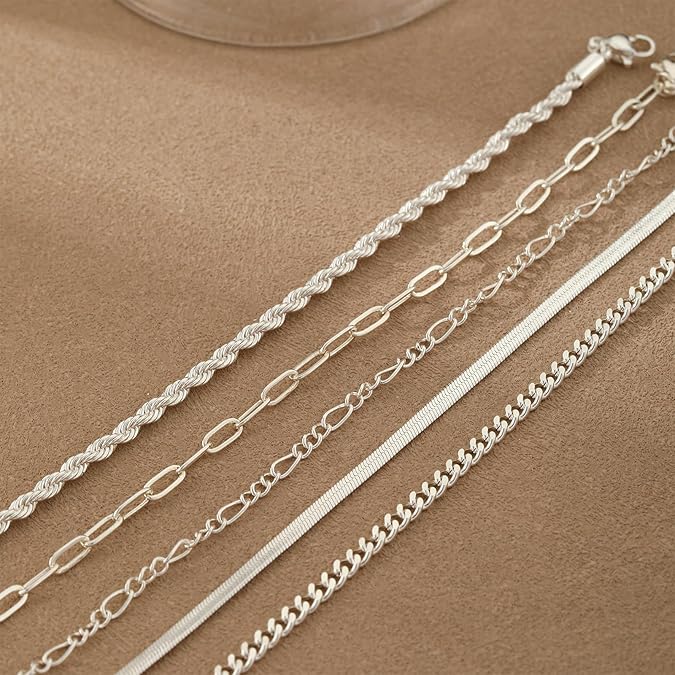 Set of silver chains on a beige surface