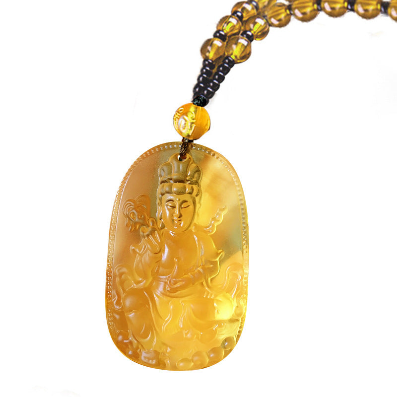 Yellow jade pendant with intricate carvings on a white background