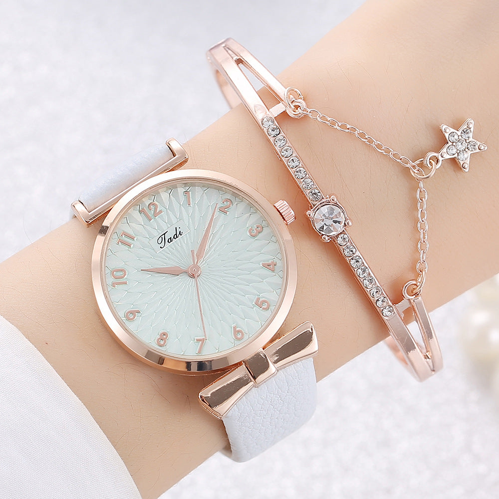 Rose gold watch and bracelet set on a wrist against a light background
