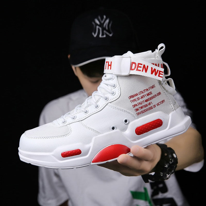 White high-top sneakers with red accents held by a person wearing a black cap.