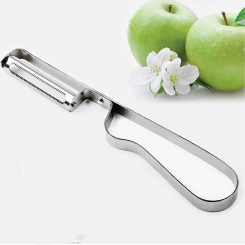 Metal apple peeler with two green apples and a white flower on a white background