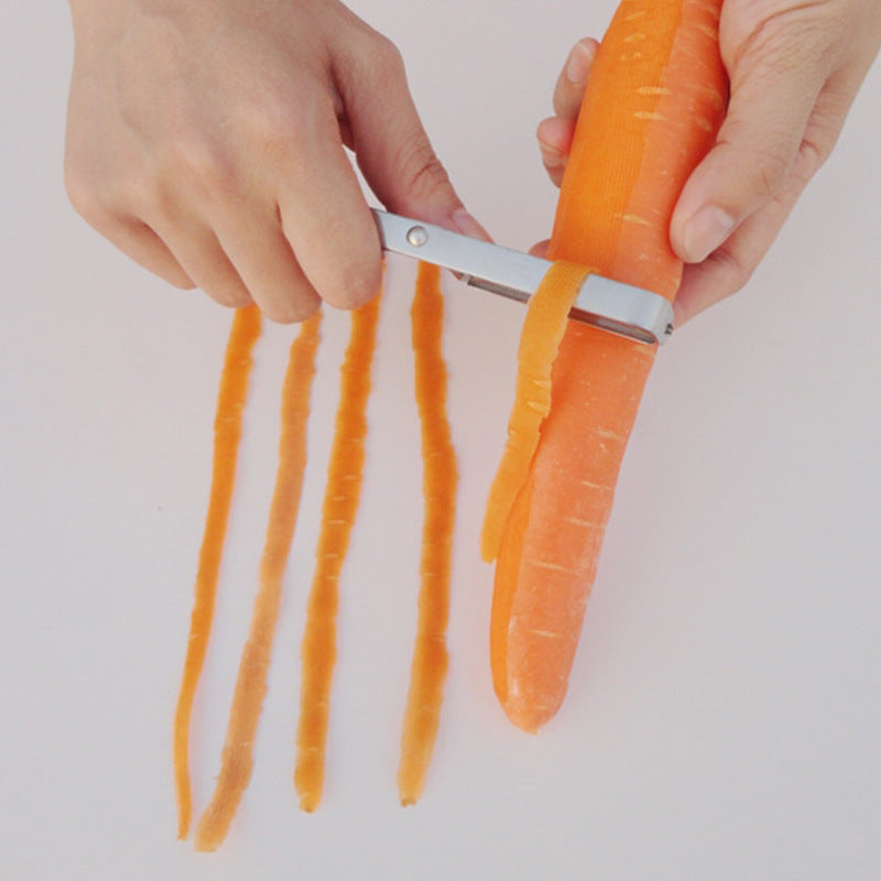 Carrot being peeled with a peeler on a white background