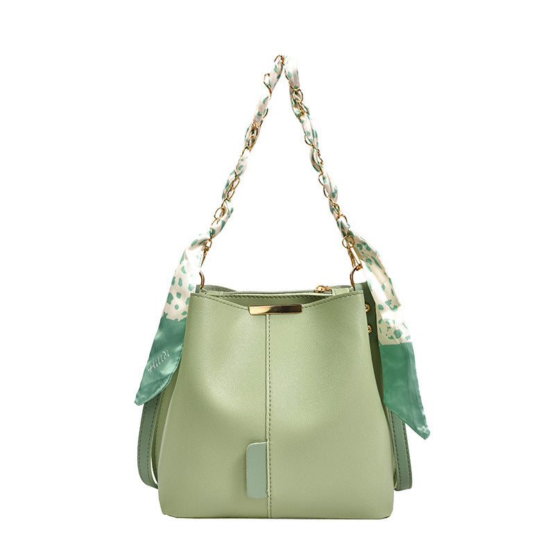 Green handbag with floral strap on a white background