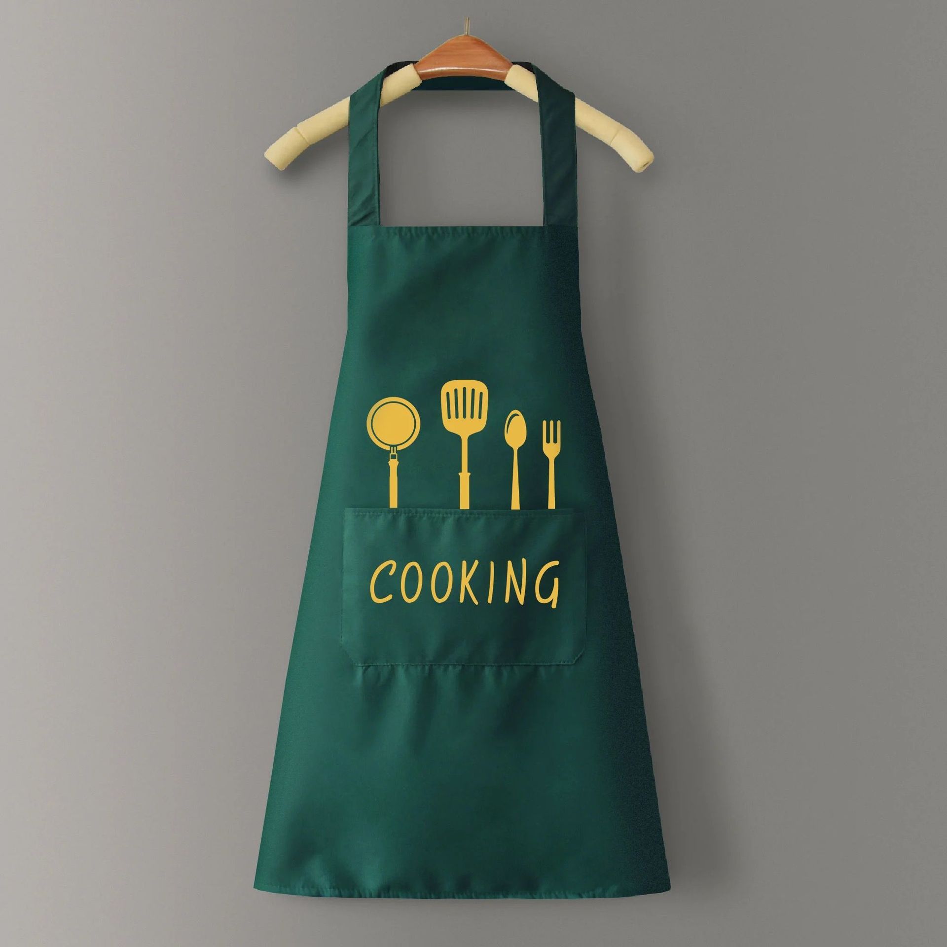 Green apron with yellow cooking utensil icons and 'COOKING' text on a gray background