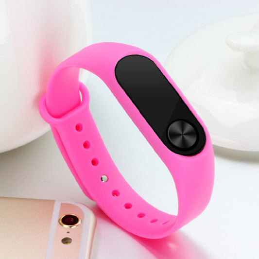 Pink smartwatch band with black button on a white background