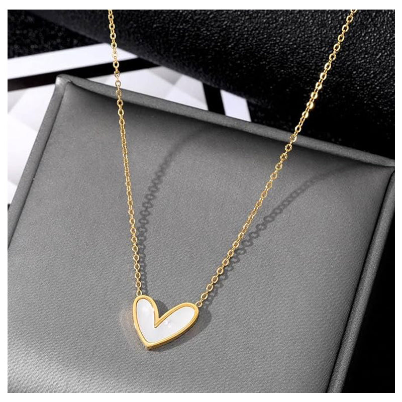 Gold necklace with a heart-shaped pendant on a gray surface