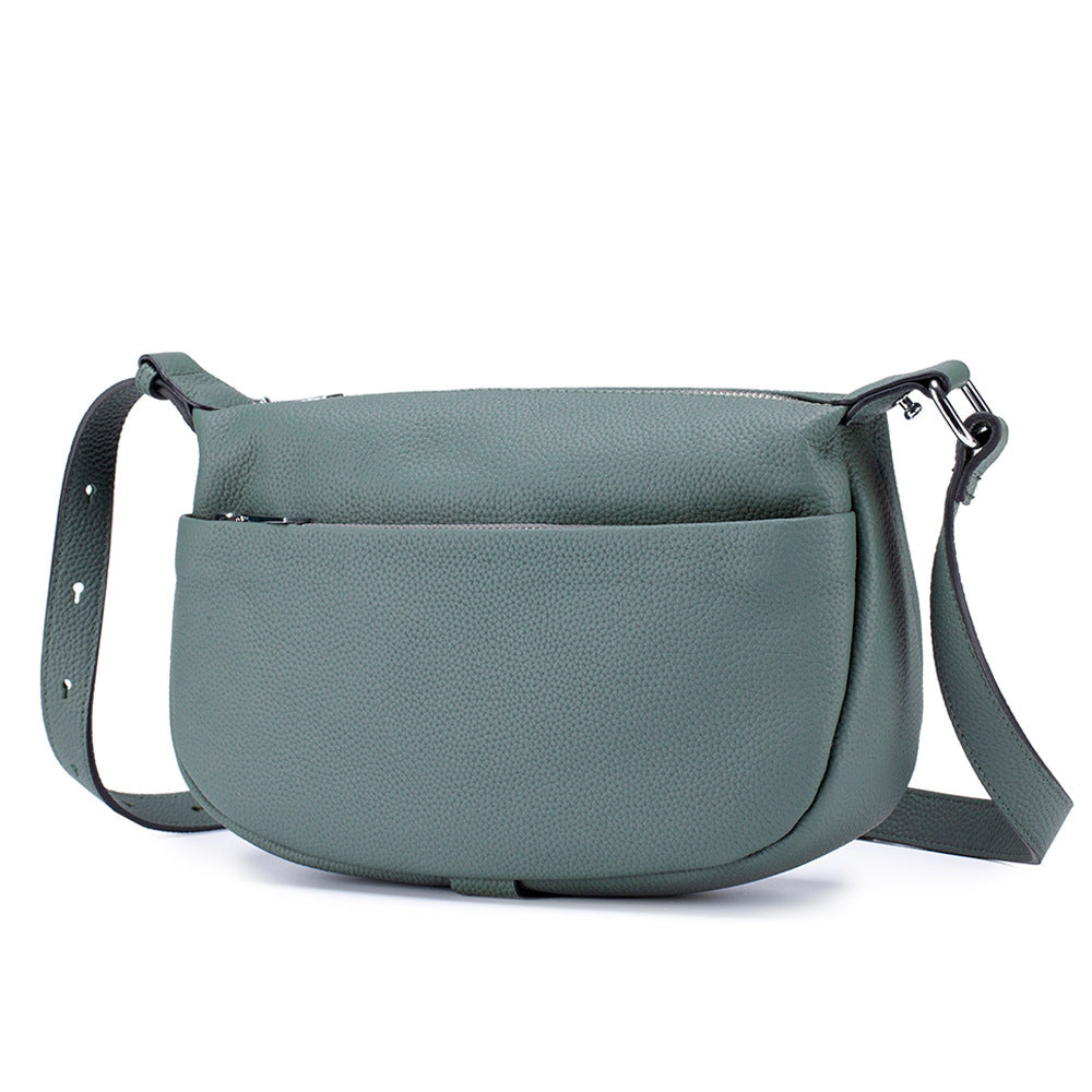 Green leather handbag with a strap on a white background