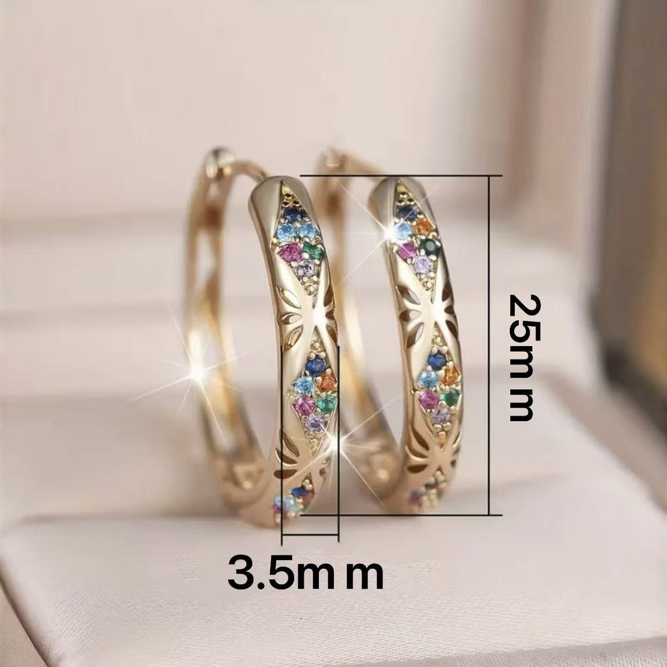 Gold hoop earrings with colorful gemstones and measurements on a light background