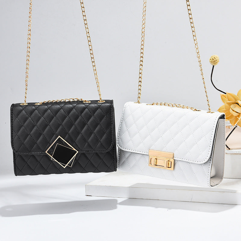 Black and white handbags with gold chains on a light gray background