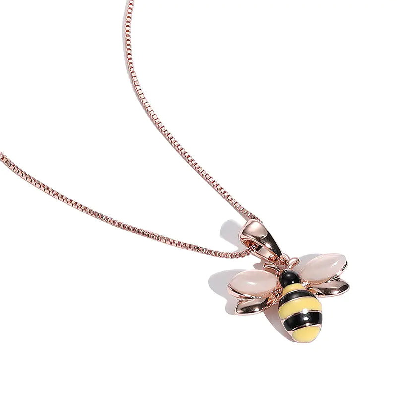 Rose gold bee pendant necklace on a white background