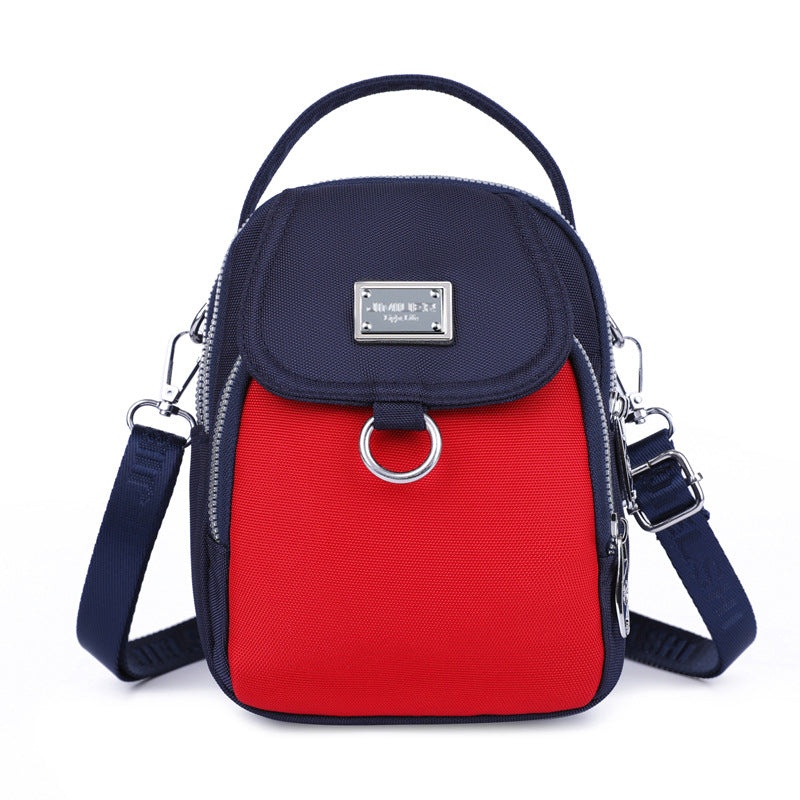 Navy and red crossbody bag with a visible brand logo on a white background