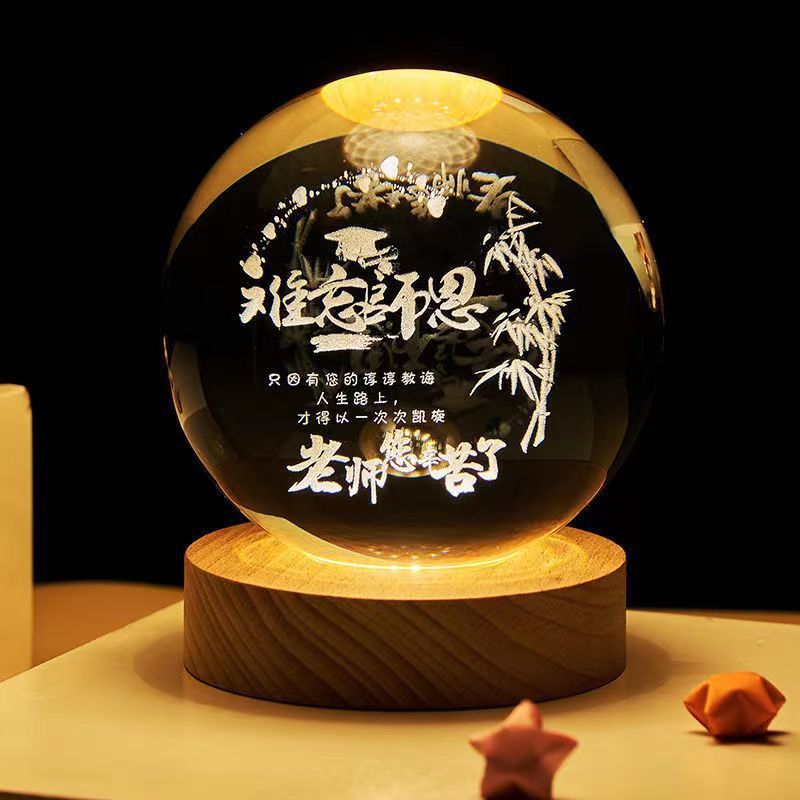 Glowing crystal ball with Chinese text and bamboo design on a wooden base against a dark background