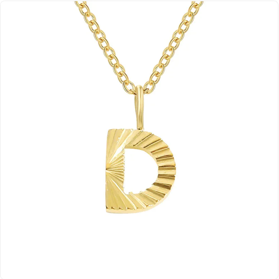 Gold necklace with a textured 'D' pendant on a white background