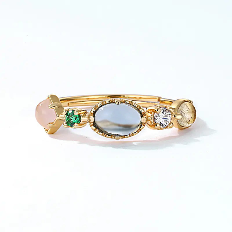 Gold ring with various gemstones on a white background