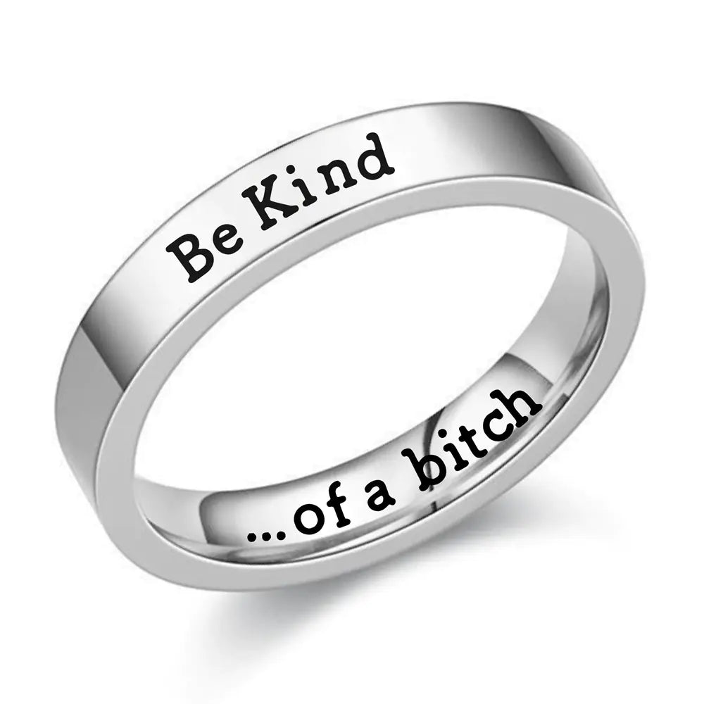 Silver ring with 'Be Kind' on one side and '...of a bitch' on the other, on a white background.