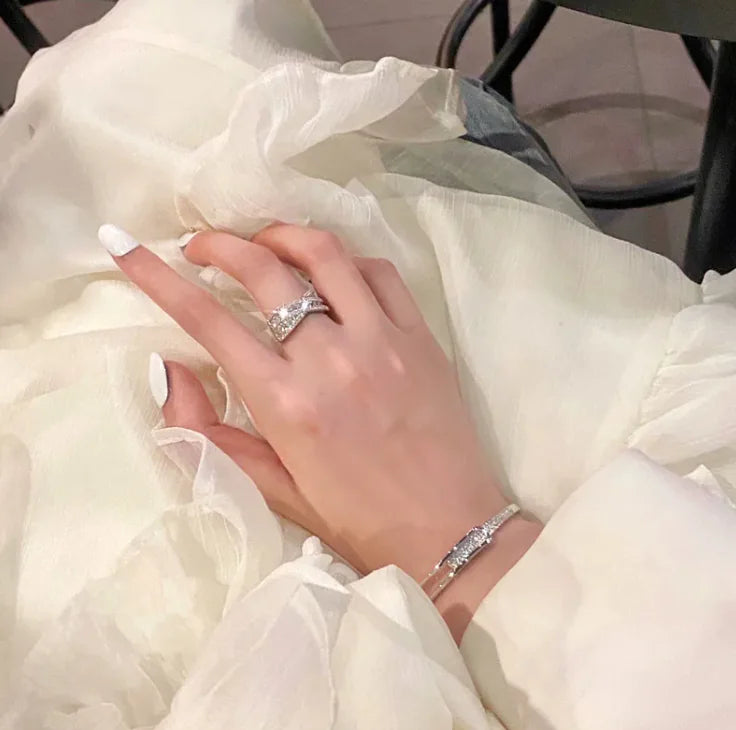 Hand wearing a silver ring with a white background