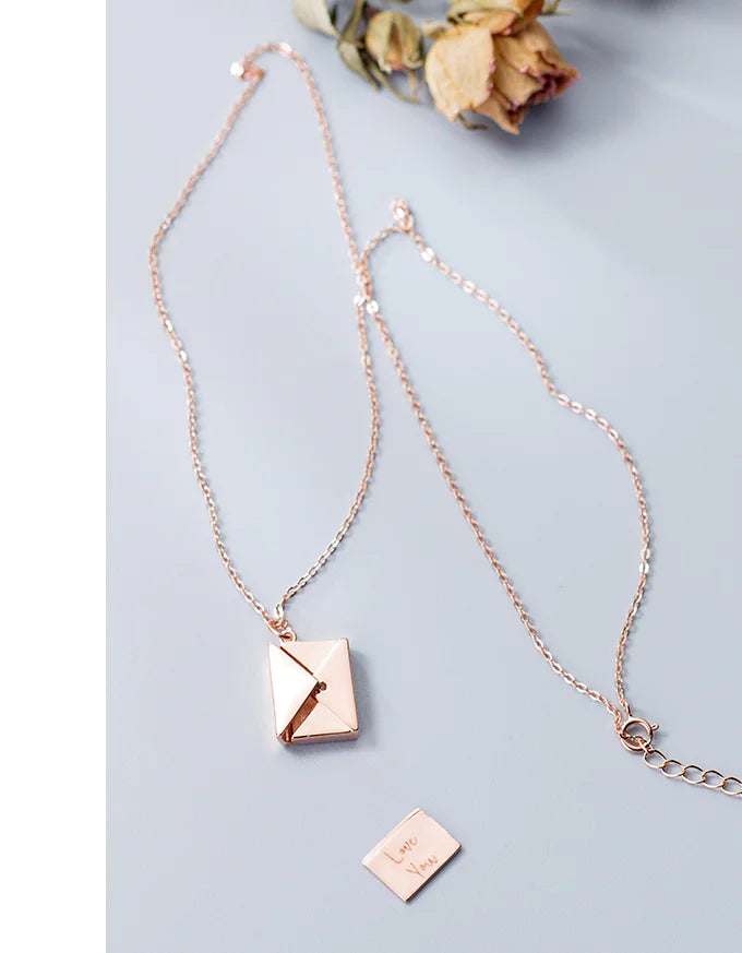 Rose gold necklace with square pendants on a light gray background