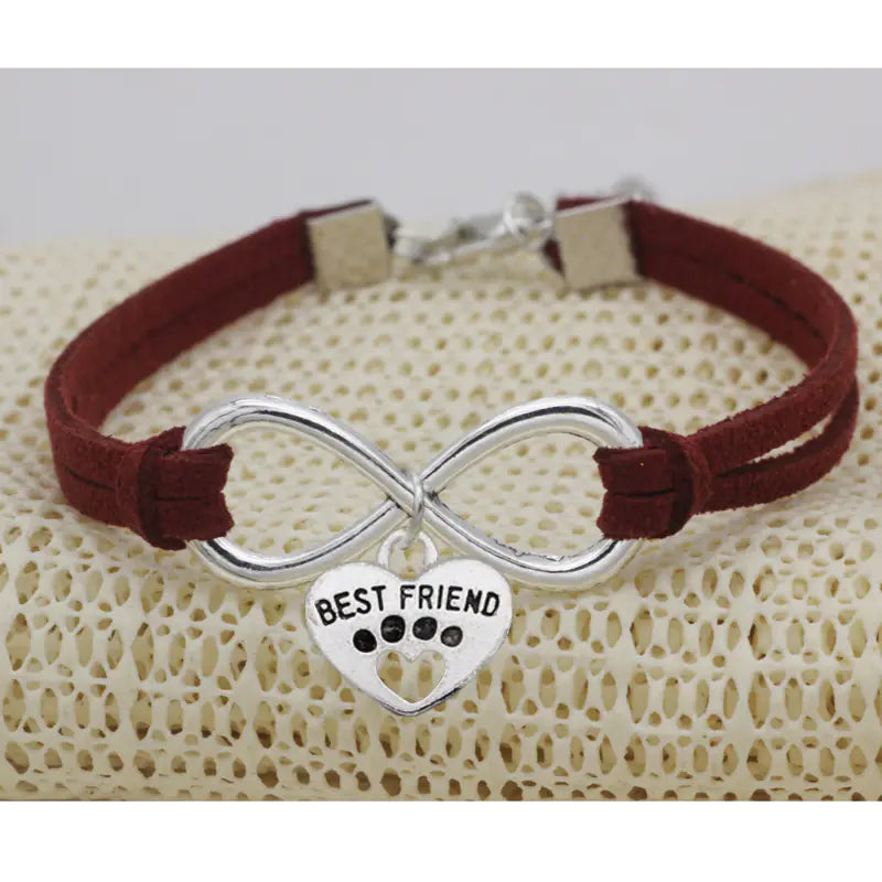 Bracelet with infinity symbol and 'Best Friend' heart charm on a textured surface