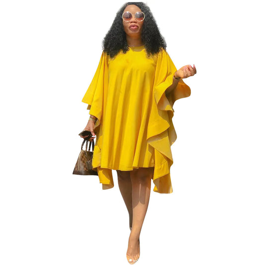 Woman wearing a yellow dress holding a handbag on a white background