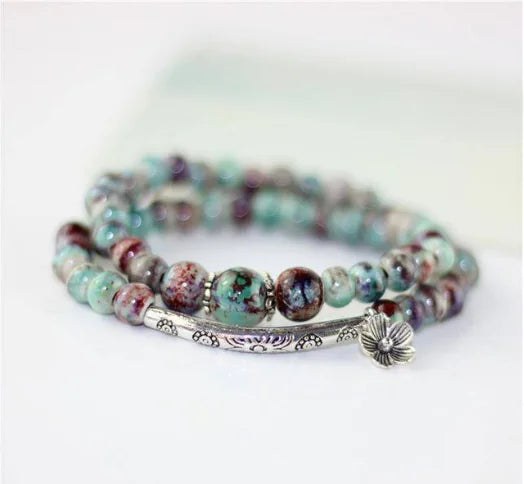 Multicolored beaded bracelet with a silver clasp on a white background