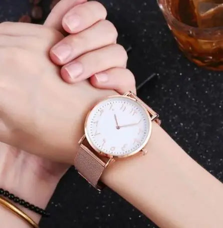 Rose gold watch on a wrist with a blurred background