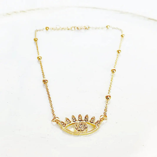 Gold necklace with an eye-shaped pendant on a white background