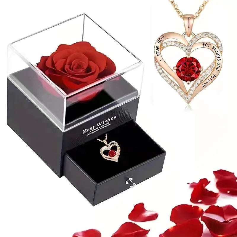 Red rose in a box, heart-shaped jewelry set with red gemstones, and red rose petals on a white background.