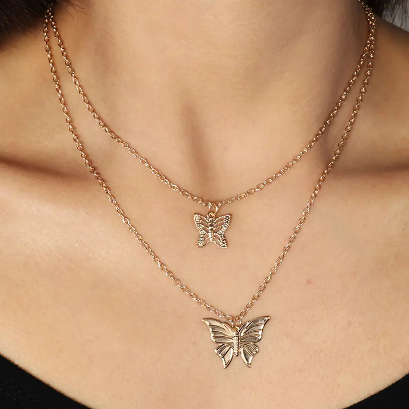 Rose gold butterfly necklaces on a person's neck