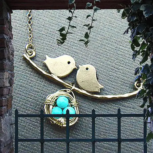 Decorative hanging ornament with birds and a nest on a wall.
